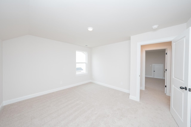 spare room with light carpet and baseboards