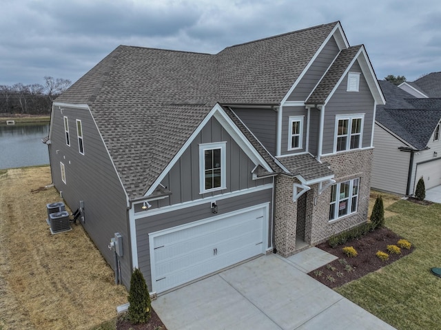 view of front of home with a shingled roof, brick siding, driveway, and board and batten siding