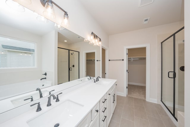 bathroom with a stall shower, visible vents, and a sink