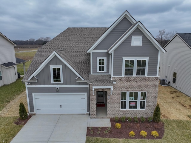 view of front of house with driveway, board and batten siding, cooling unit, and roof with shingles