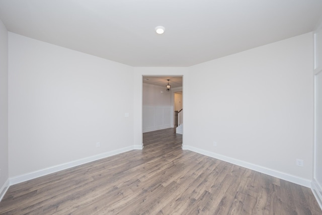 empty room with baseboards and wood finished floors