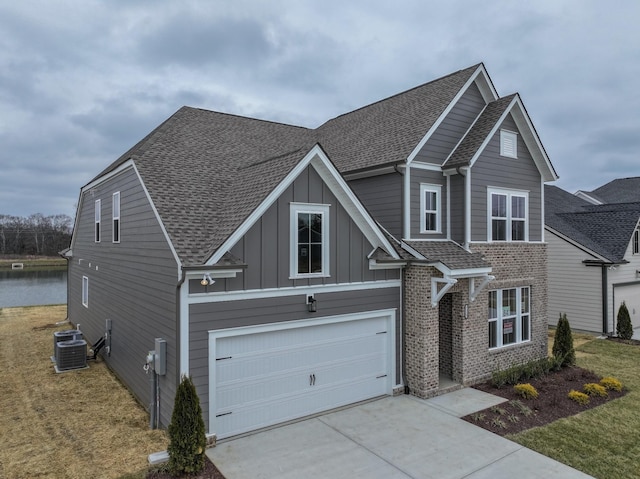 view of front of property featuring a shingled roof, concrete driveway, brick siding, and board and batten siding