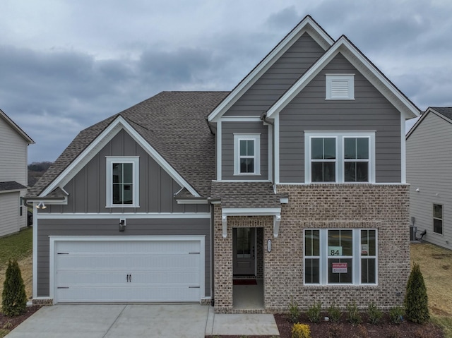 view of front of home with board and batten siding, brick siding, driveway, and roof with shingles