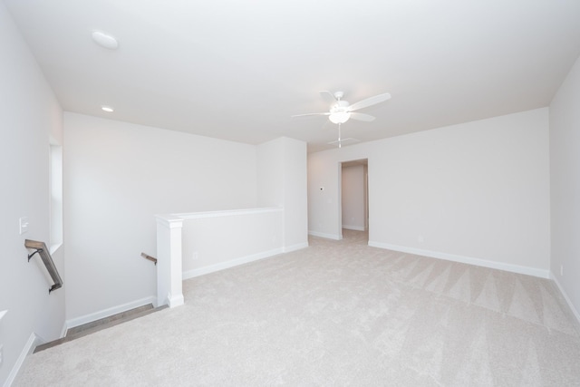 empty room with light colored carpet, ceiling fan, and baseboards