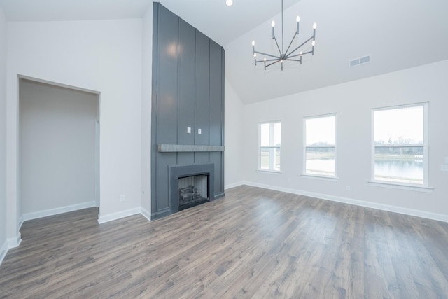 unfurnished living room featuring high vaulted ceiling, a fireplace, wood finished floors, visible vents, and baseboards