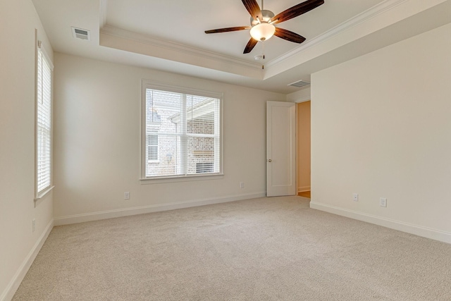 spare room featuring visible vents, a tray ceiling, and ornamental molding