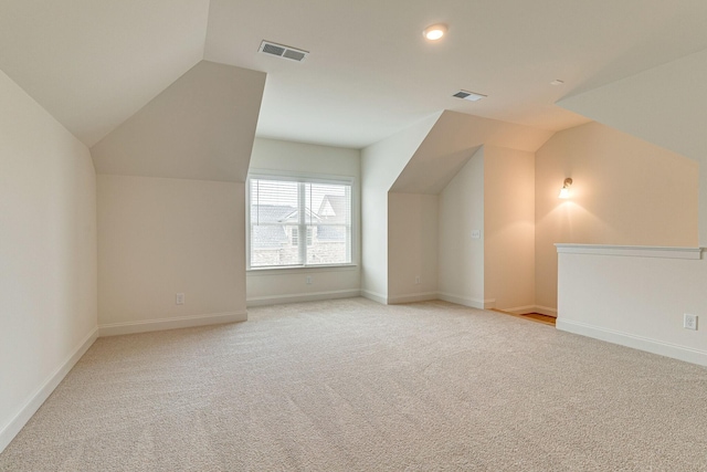 bonus room featuring vaulted ceiling, baseboards, visible vents, and light colored carpet