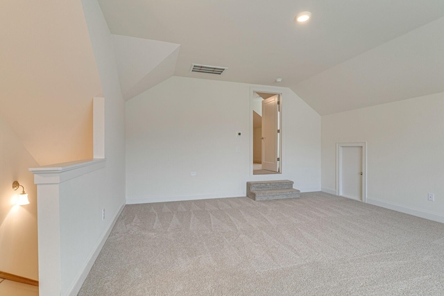 additional living space featuring lofted ceiling, baseboards, visible vents, and carpet flooring