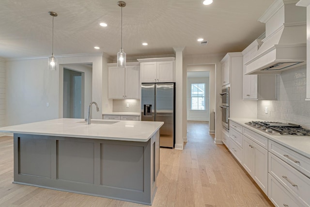 kitchen featuring appliances with stainless steel finishes, light wood-type flooring, premium range hood, and ornamental molding