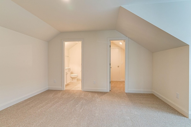 additional living space with light carpet, baseboards, and lofted ceiling