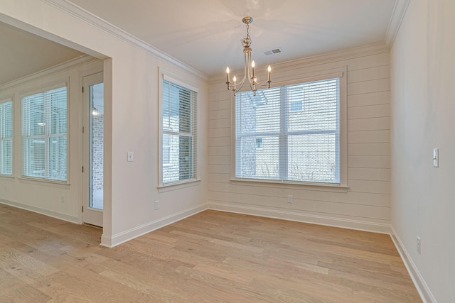 unfurnished dining area with a chandelier, visible vents, baseboards, light wood-style floors, and crown molding