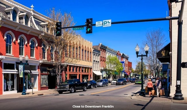 view of street featuring street lights, curbs, traffic lights, and sidewalks