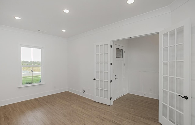 unfurnished room featuring crown molding, recessed lighting, visible vents, wood finished floors, and baseboards