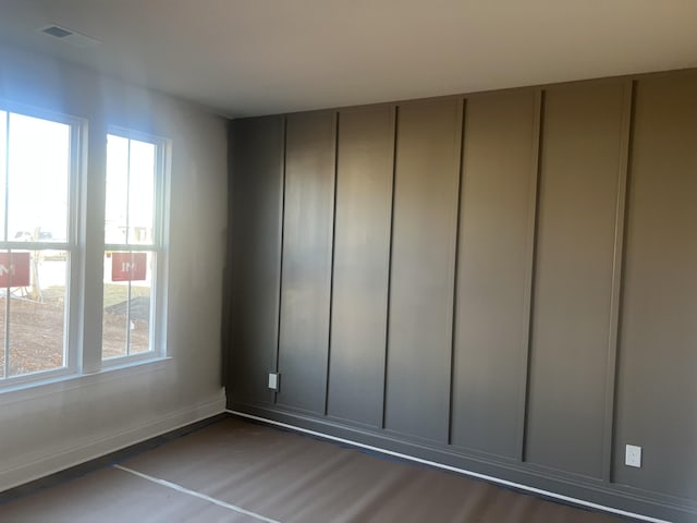 spare room featuring dark wood-style floors and visible vents