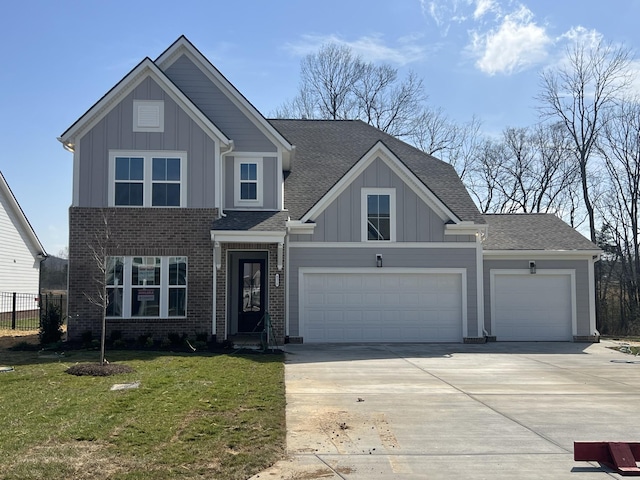 view of front facade with board and batten siding, concrete driveway, a front lawn, and fence