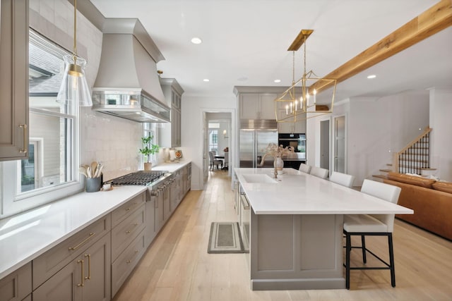 6324 Percheron Ln, Arrington, TN 37014 - kitchen with appliances with stainless steel finishes, a breakfast bar area, gray cabinetry, premium range hood, and backsplash