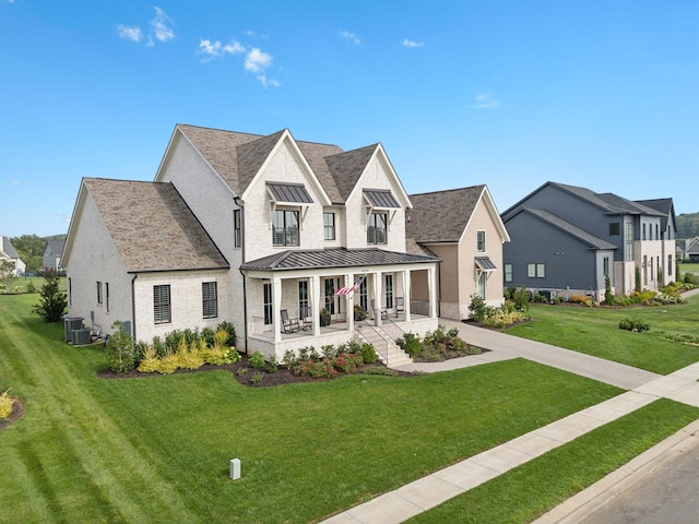 modern farmhouse style home with central AC unit, metal roof, a standing seam roof, covered porch, and a front lawn