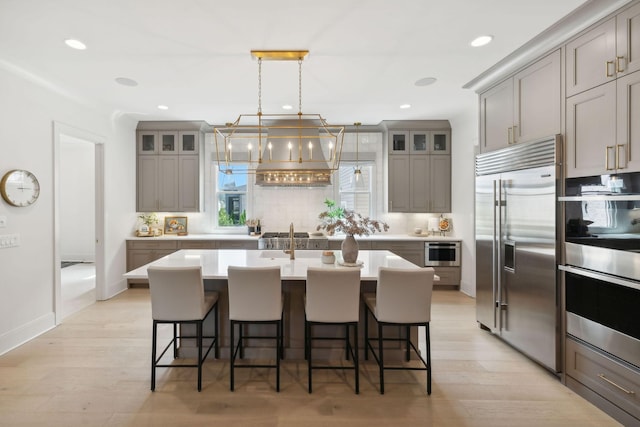 6324 Percheron Ln, Arrington, TN 37014 - kitchen featuring glass insert cabinets, a breakfast bar, gray cabinets, stainless steel appliances, and premium range hood