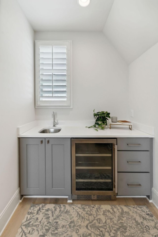 6324 Percheron Ln, Arrington, TN 37014 - bar featuring lofted ceiling, beverage cooler, a sink, baseboards, and light wood-type flooring