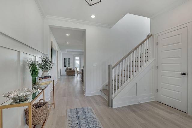 foyer featuring light wood-style flooring, ornamental molding, recessed lighting, stairway, and baseboards