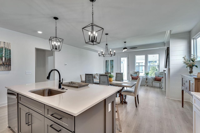 kitchen with open floor plan, gray cabinets, dishwasher, and a sink