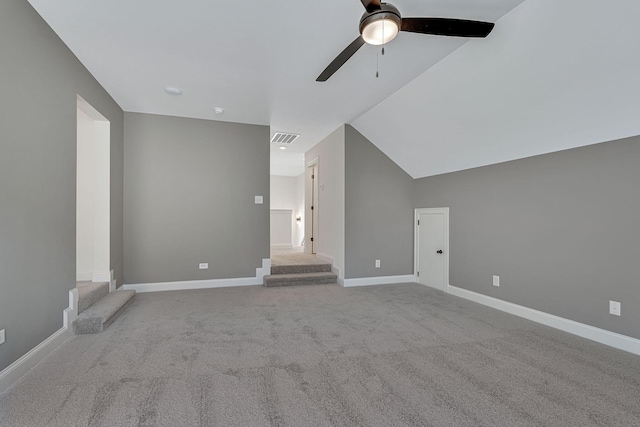 interior space featuring visible vents, lofted ceiling, carpet floors, baseboards, and ceiling fan