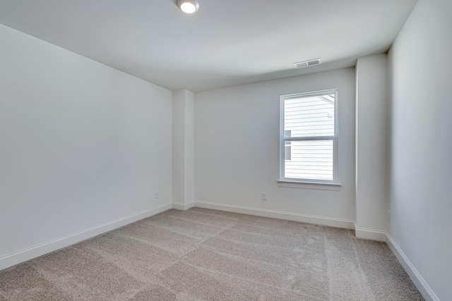 unfurnished room with light carpet, visible vents, and baseboards