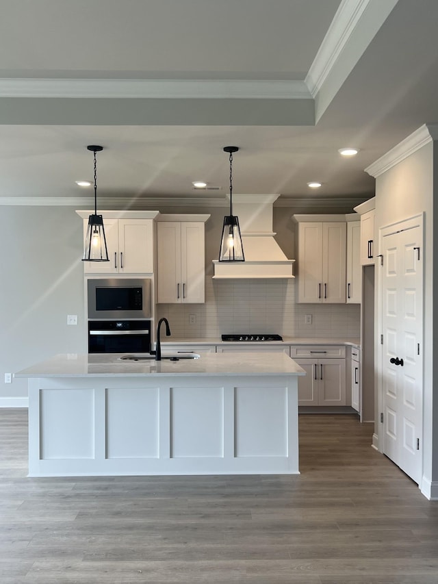 kitchen with crown molding, custom exhaust hood, light countertops, decorative backsplash, and appliances with stainless steel finishes