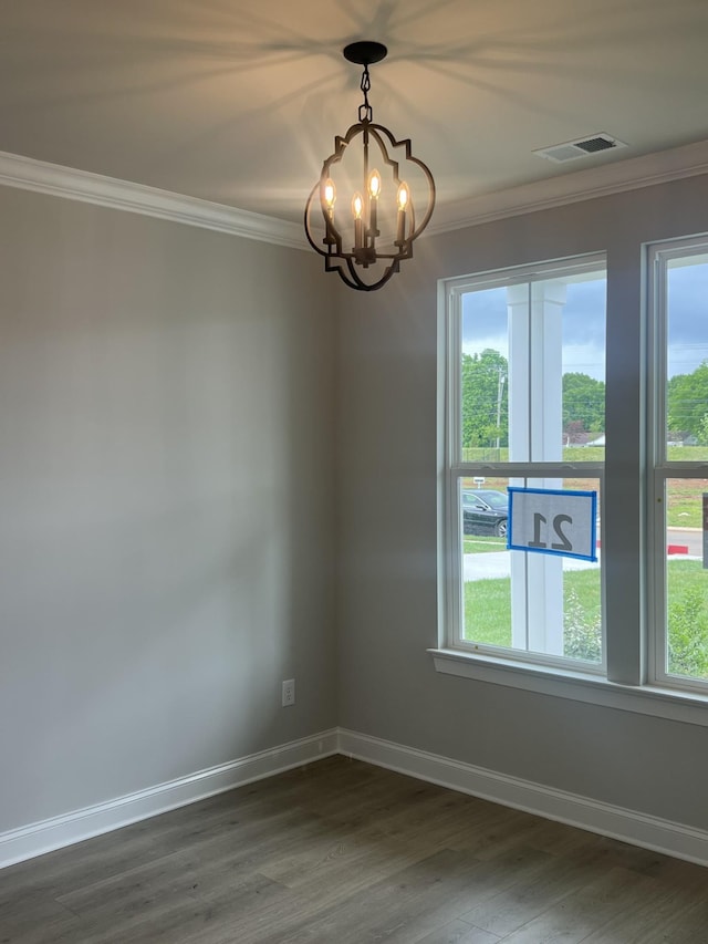 unfurnished room featuring a chandelier, plenty of natural light, dark wood-style floors, and ornamental molding