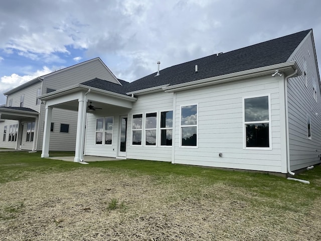 back of property with a yard, a shingled roof, a patio area, and a ceiling fan