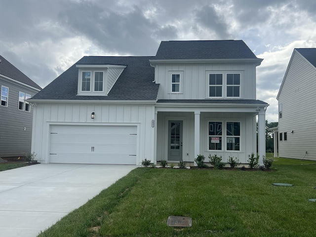 view of front of house featuring a garage, driveway, roof with shingles, a front lawn, and board and batten siding