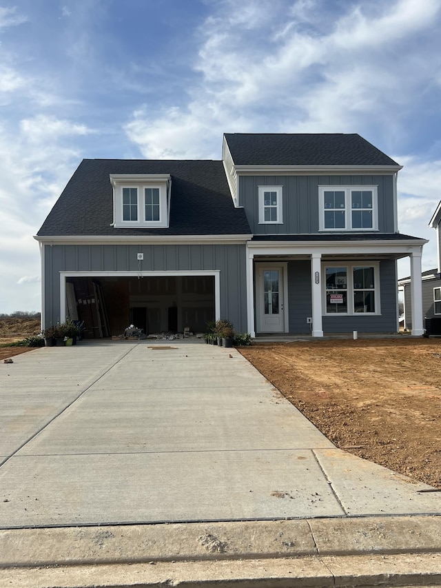 modern farmhouse style home with board and batten siding, an attached garage, driveway, and roof with shingles