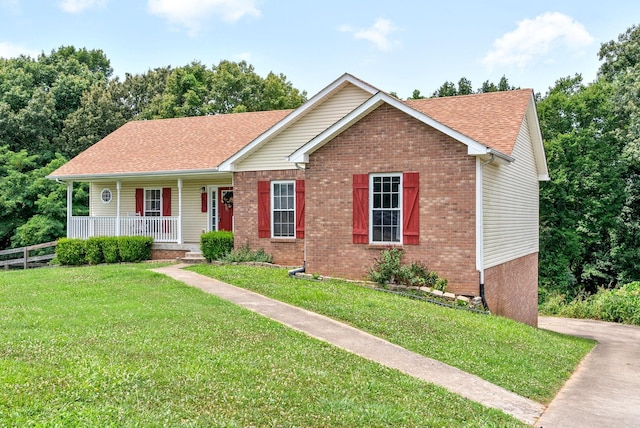 ranch-style home featuring brick siding, a shingled roof, covered porch, a front yard, and fence