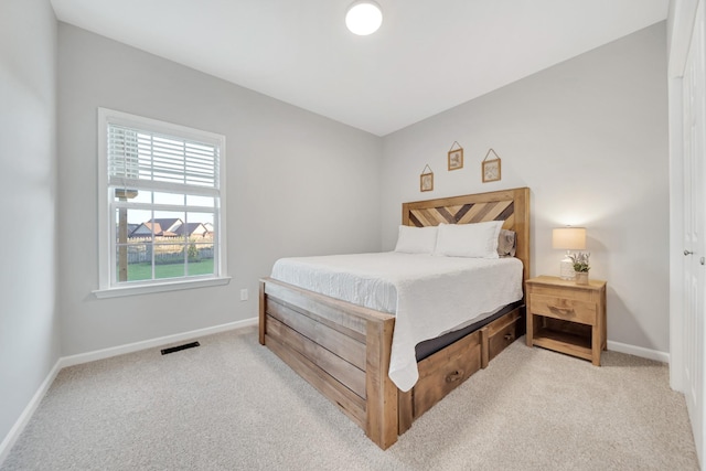 carpeted bedroom featuring visible vents and baseboards