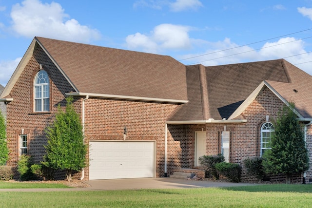 view of front of home with driveway, a shingled roof, an attached garage, and brick siding