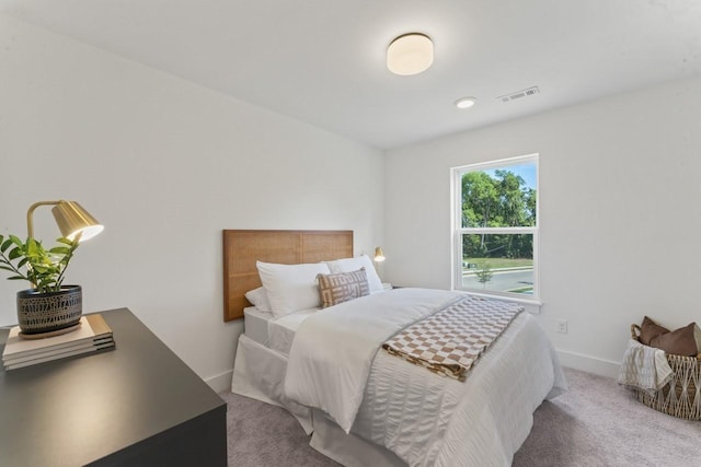 carpeted bedroom with visible vents and baseboards