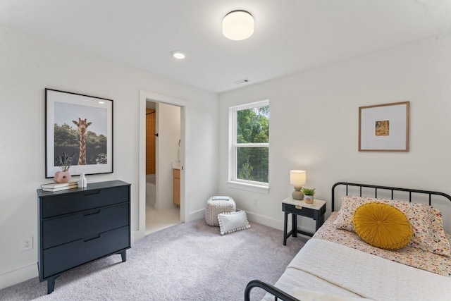 bedroom featuring light carpet, ensuite bath, visible vents, and baseboards