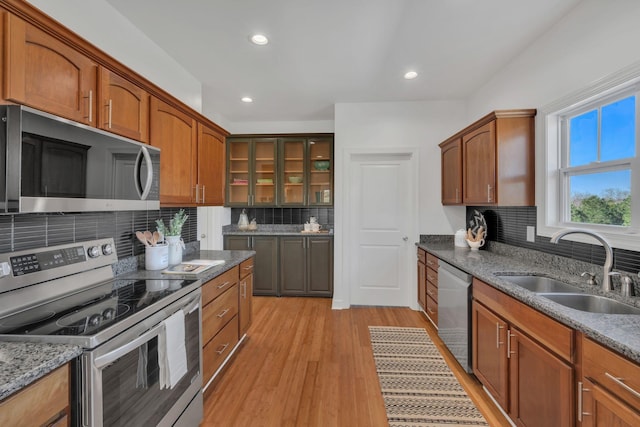 kitchen with appliances with stainless steel finishes, recessed lighting, a sink, and light wood-style floors