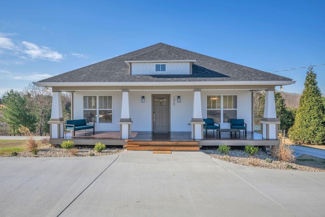 bungalow with covered porch and a shingled roof