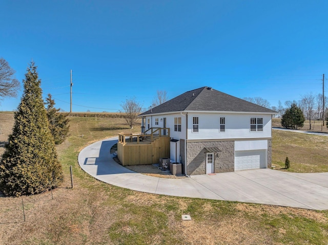 view of home's exterior featuring a garage, roof with shingles, driveway, and a lawn