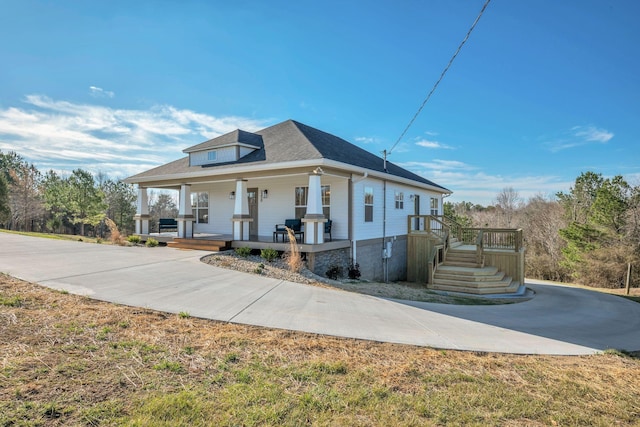 bungalow featuring covered porch and roof with shingles