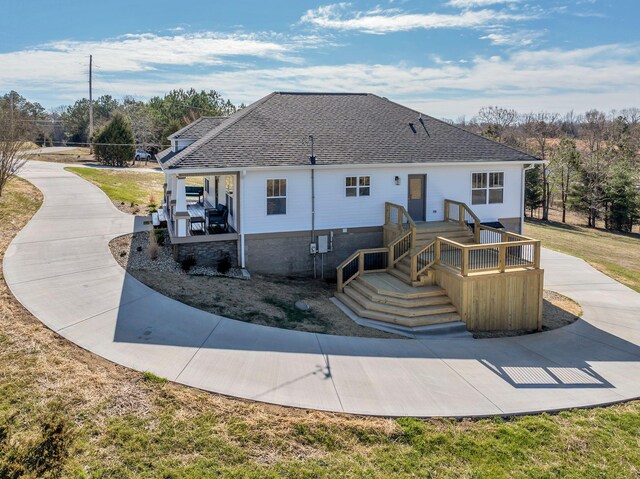 rear view of property with a shingled roof