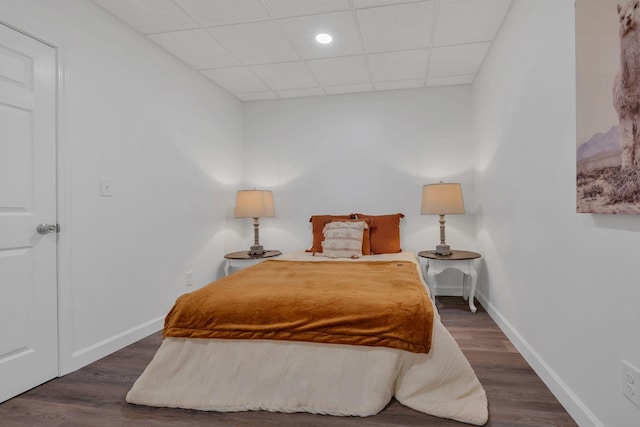 bedroom with a paneled ceiling, recessed lighting, baseboards, and wood finished floors