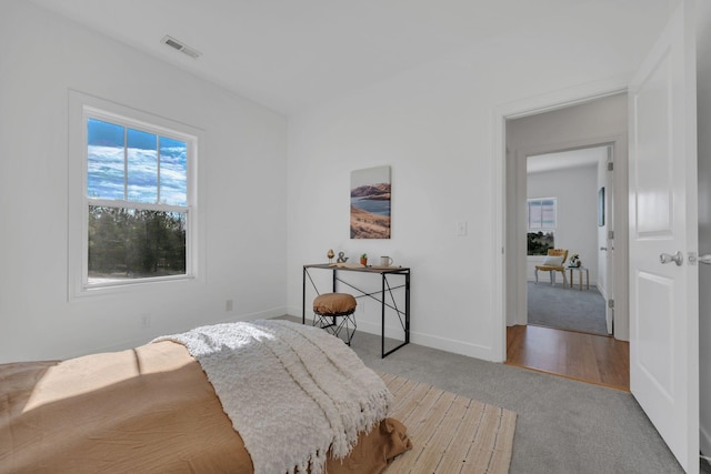 carpeted bedroom featuring baseboards and visible vents