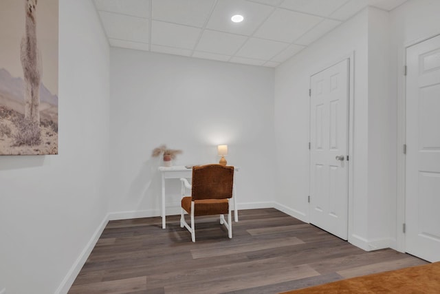 office area featuring wood finished floors, a paneled ceiling, and baseboards