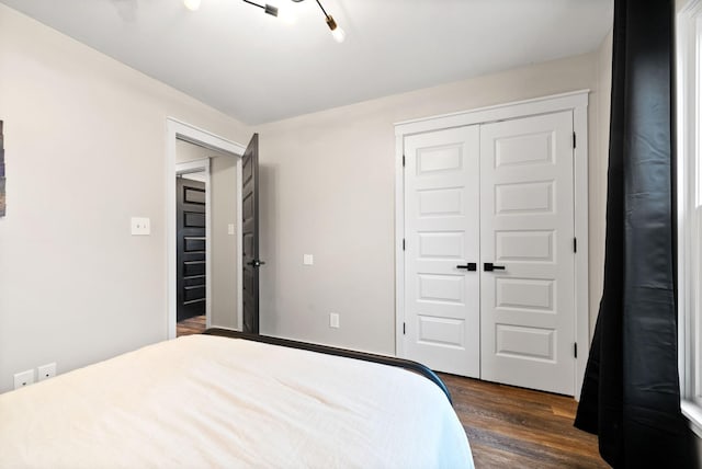 bedroom with dark wood-type flooring and a closet