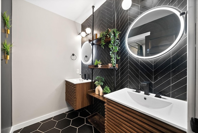 full bathroom featuring a sink, baseboards, and two vanities