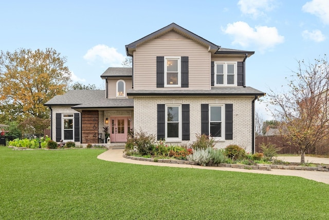 traditional-style home with brick siding, roof with shingles, and a front yard