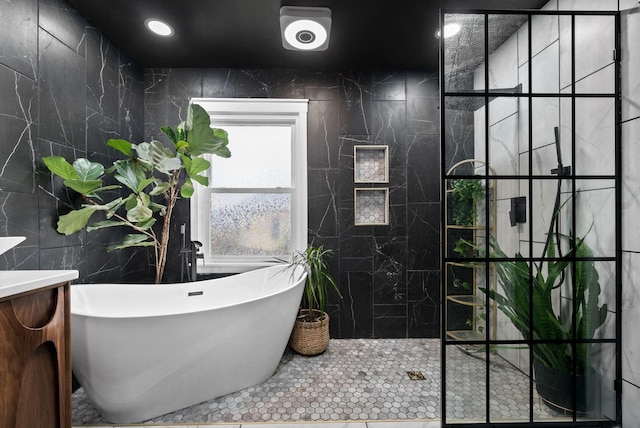 full bath with a soaking tub, tile walls, and recessed lighting