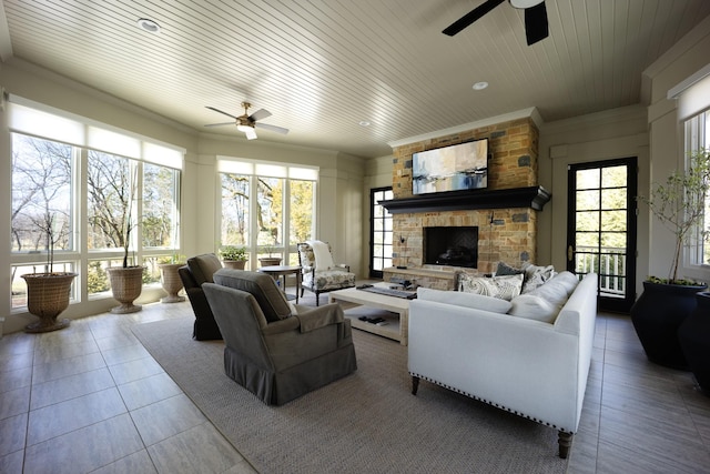 living area featuring a stone fireplace, tile patterned flooring, wood ceiling, and a ceiling fan